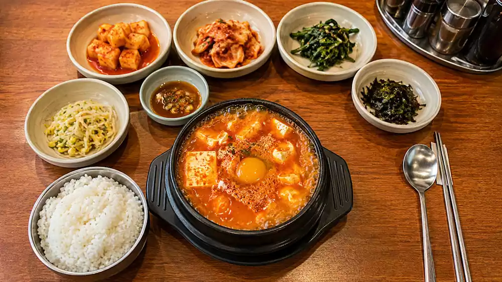 The Ultimate Guide to Sundubu Jjigae: Korea’s Famous Spicy Soft Tofu Stew | 순두부찌개 2 Korean soft tofu stew table